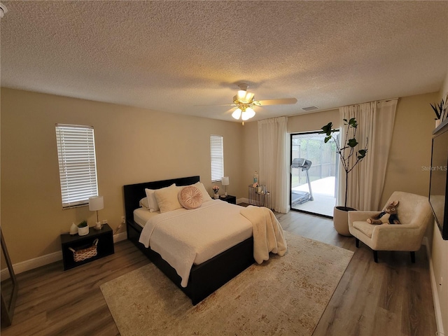 bedroom with ceiling fan, wood-type flooring, access to outside, and multiple windows