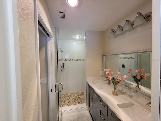 bathroom featuring a shower with shower door and vanity