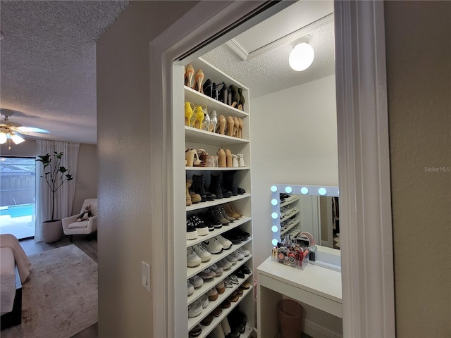 wine room with a textured ceiling and ceiling fan