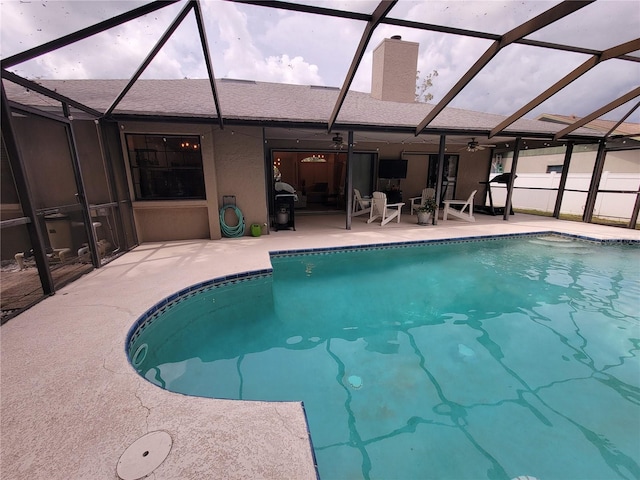 view of pool featuring ceiling fan, a patio area, and glass enclosure