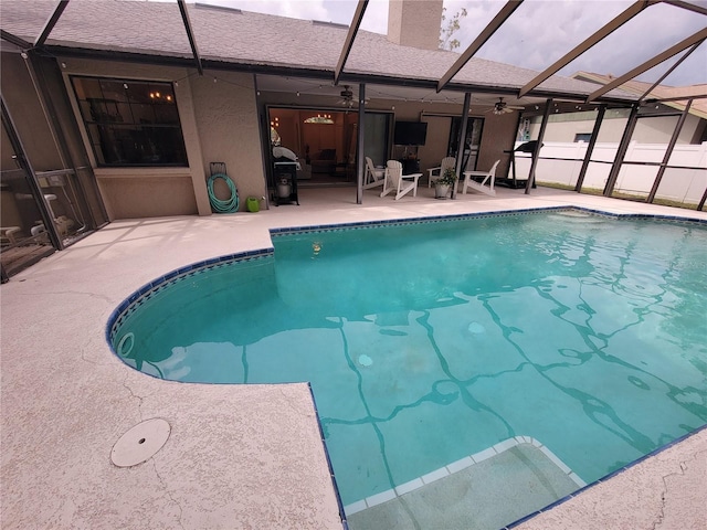 view of swimming pool with glass enclosure and a patio