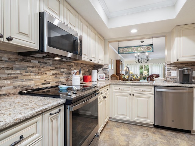 kitchen featuring pendant lighting, tasteful backsplash, ornamental molding, a tray ceiling, and stainless steel appliances