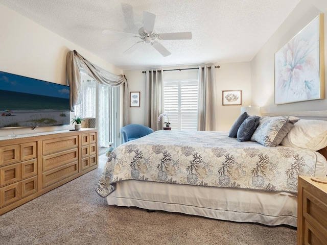 carpeted bedroom featuring ceiling fan and a textured ceiling