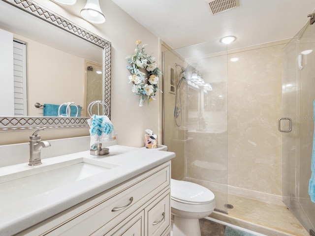 bathroom with vanity, an enclosed shower, and toilet