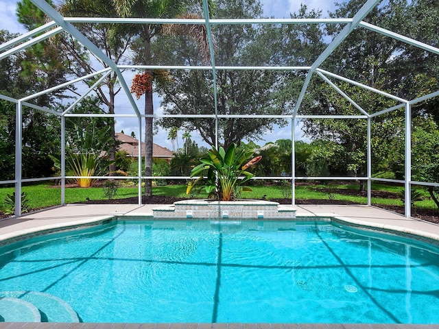 view of pool featuring a lanai, a lawn, pool water feature, and a patio area