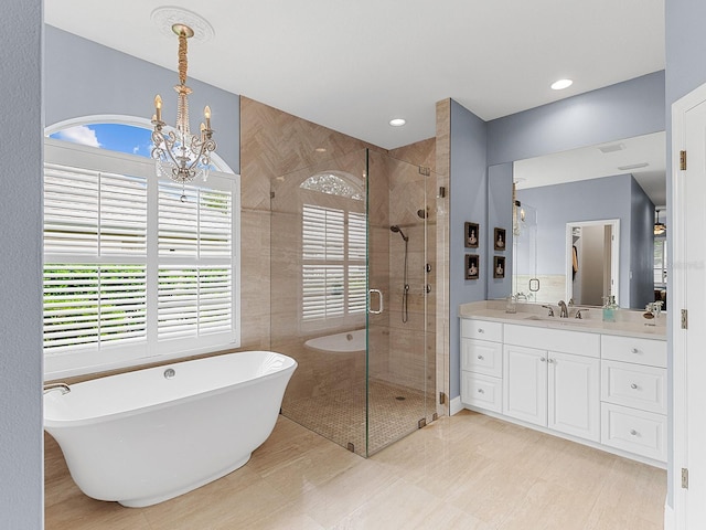 bathroom featuring vanity, a chandelier, shower with separate bathtub, and a healthy amount of sunlight