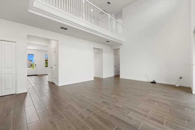 unfurnished living room featuring a high ceiling