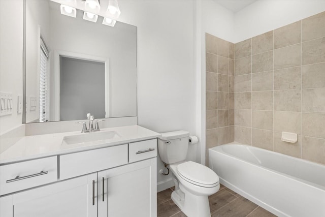 full bathroom featuring tiled shower / bath, vanity, and toilet