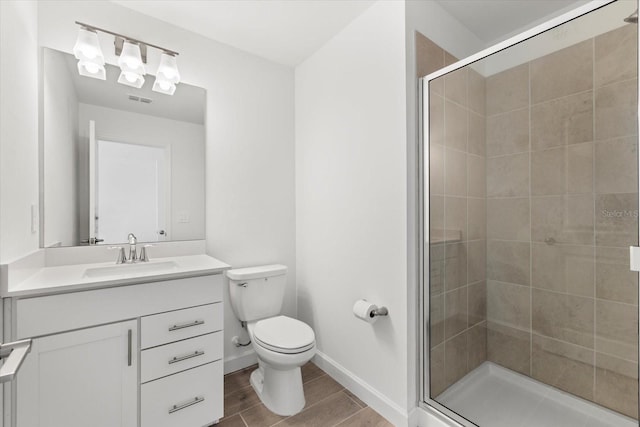 bathroom with vanity, toilet, and a shower with shower door