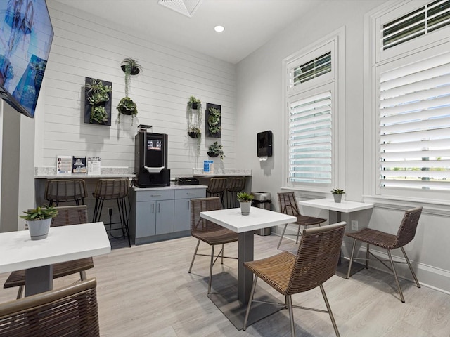 dining room with wooden walls and light wood-type flooring