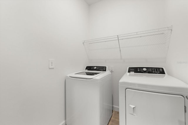 laundry area with washer and dryer and wood-type flooring