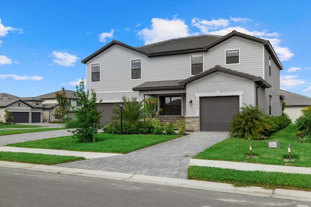 view of property with a garage and a front lawn