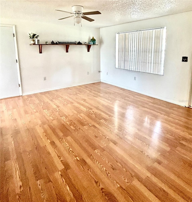 spare room with ceiling fan, a textured ceiling, and light wood-type flooring