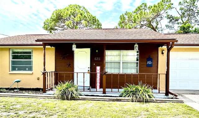 single story home with an attached garage, stucco siding, a front yard, and roof with shingles