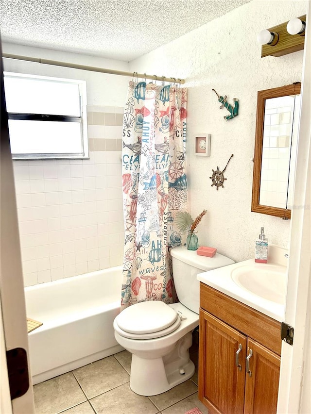 bathroom with a textured ceiling, a textured wall, toilet, vanity, and tile patterned floors