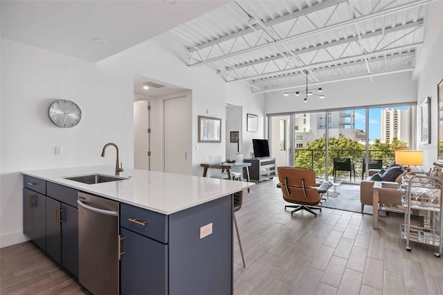 kitchen featuring hardwood / wood-style flooring, a kitchen breakfast bar, sink, and stainless steel dishwasher