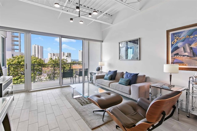 living room featuring light hardwood / wood-style flooring, a wealth of natural light, and a towering ceiling