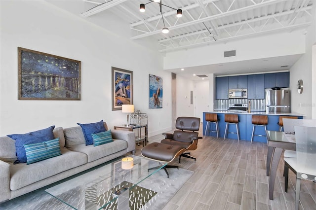 living room with light hardwood / wood-style flooring and a high ceiling