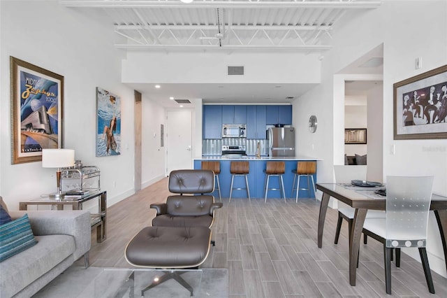 living room featuring light hardwood / wood-style flooring and a towering ceiling