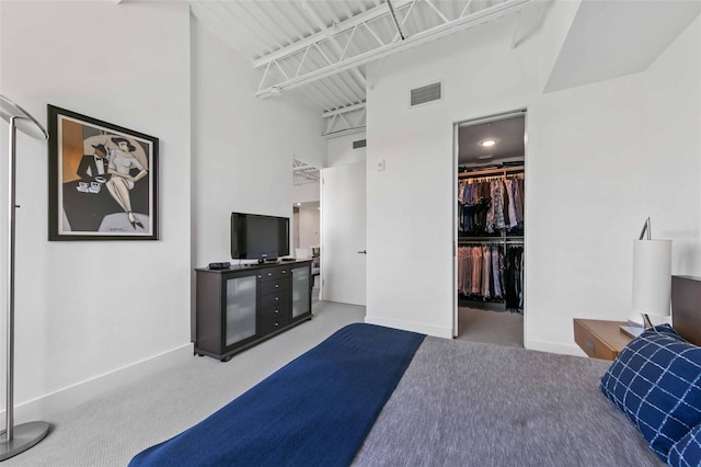 carpeted bedroom featuring a towering ceiling, a closet, and a walk in closet