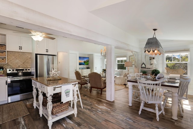 kitchen with pendant lighting, white cabinets, decorative backsplash, dark stone countertops, and appliances with stainless steel finishes