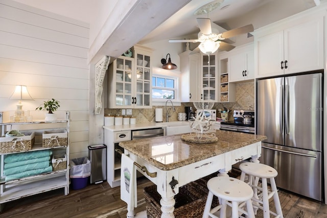 kitchen featuring dark wood-type flooring, white cabinets, sink, light stone countertops, and appliances with stainless steel finishes