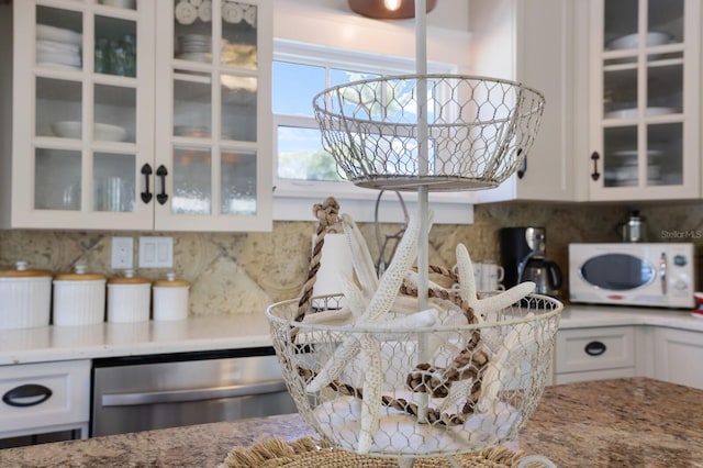 kitchen featuring dishwasher, white cabinetry, and backsplash