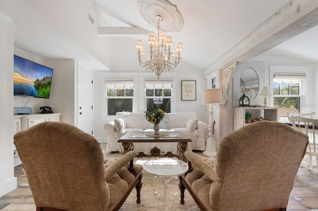 living room featuring lofted ceiling with beams, light wood-type flooring, and a notable chandelier