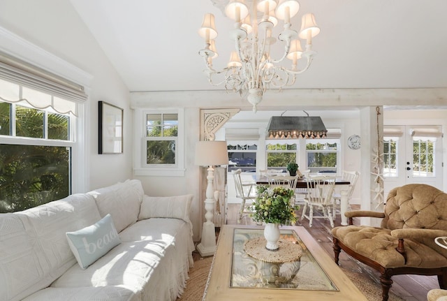 living room featuring a chandelier, french doors, and vaulted ceiling