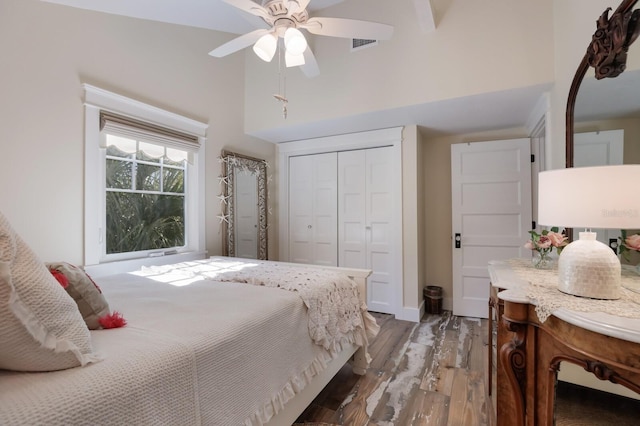 bedroom featuring ceiling fan, a closet, high vaulted ceiling, and dark hardwood / wood-style floors