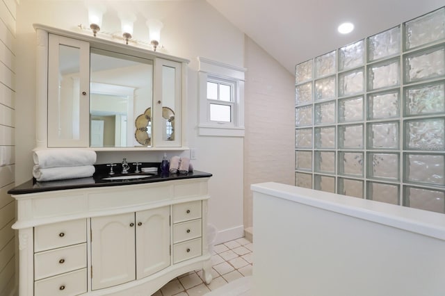 bathroom with tile patterned floors, vanity, and lofted ceiling