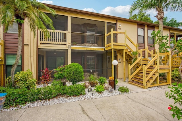 rear view of property featuring a sunroom