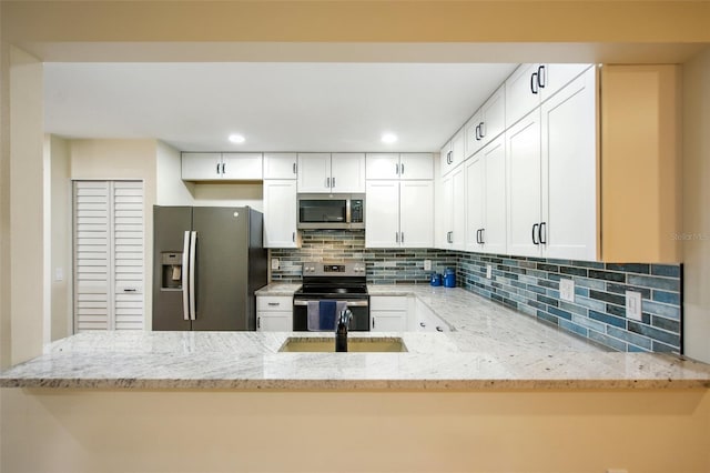 kitchen featuring white cabinets, light stone countertops, and appliances with stainless steel finishes