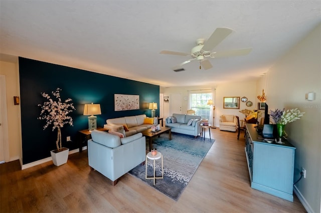 living room with wood-type flooring and ceiling fan