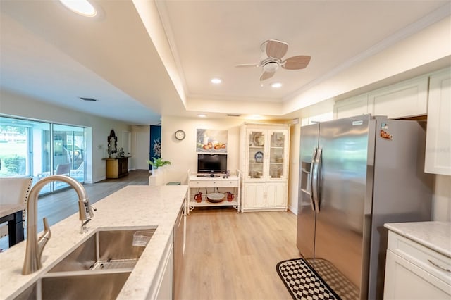 kitchen featuring white cabinetry, light hardwood / wood-style flooring, ceiling fan, sink, and stainless steel refrigerator with ice dispenser