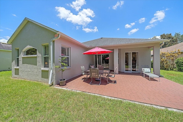 back of house with a yard and a patio