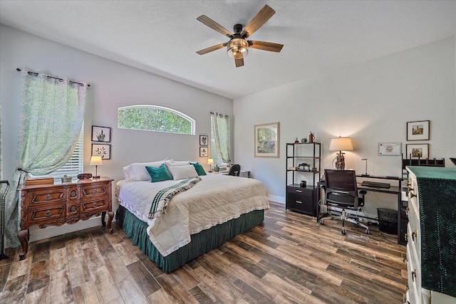 bedroom featuring a textured ceiling, dark hardwood / wood-style floors, and ceiling fan