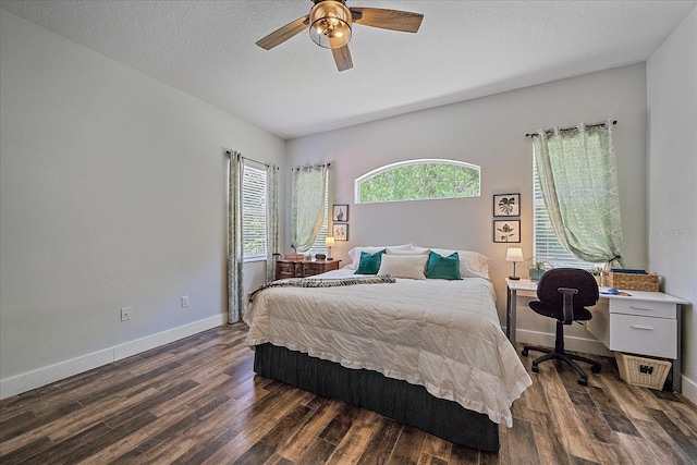 bedroom with ceiling fan, dark hardwood / wood-style flooring, and a textured ceiling