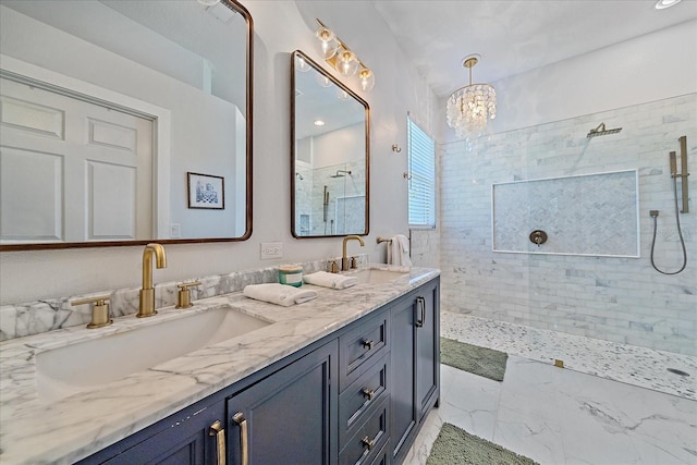 bathroom with a tile shower, vanity, and a notable chandelier