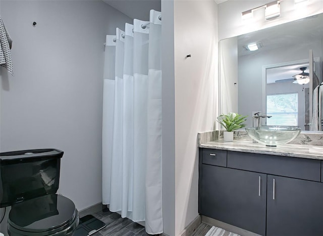 bathroom featuring vanity, toilet, and ceiling fan