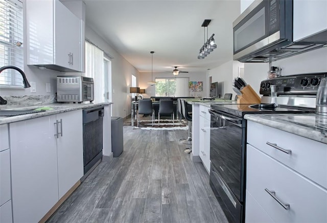 kitchen with white cabinets, dark hardwood / wood-style flooring, ceiling fan, black appliances, and sink