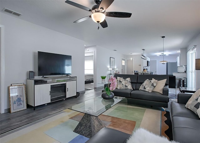 living room with dark wood-type flooring and ceiling fan