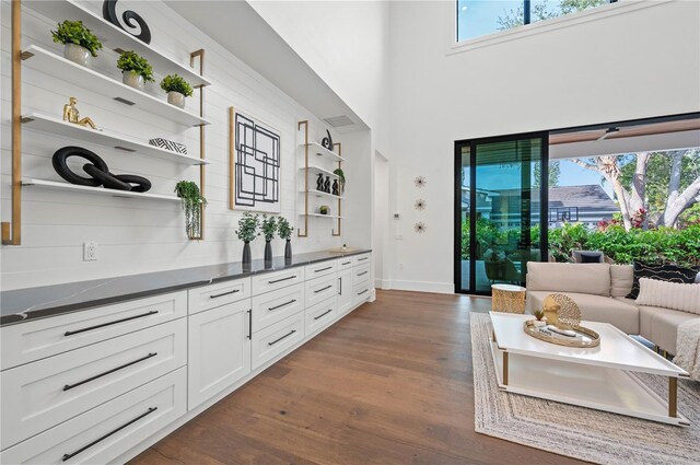 living room with dark hardwood / wood-style floors and a high ceiling