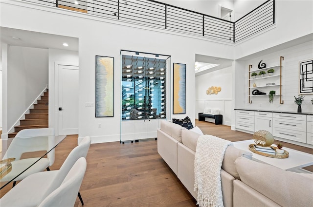 living room featuring hardwood / wood-style flooring, built in shelves, and a high ceiling