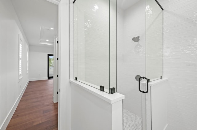 bathroom with a shower with door and hardwood / wood-style flooring