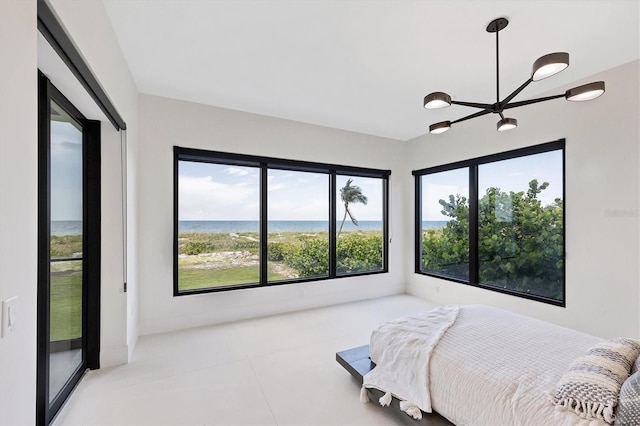 bedroom with a water view, light tile patterned floors, and a notable chandelier