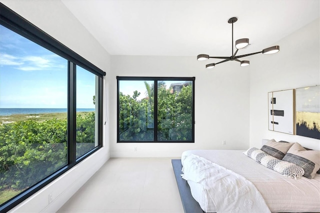 bedroom featuring a chandelier and a water view