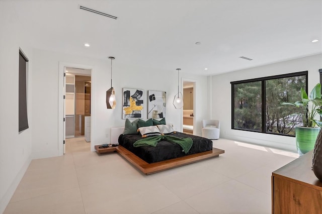 bedroom with ensuite bath and light tile patterned flooring