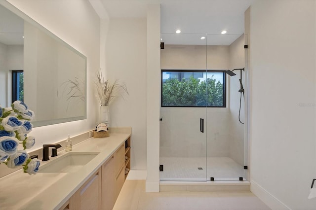 bathroom with an enclosed shower, vanity, and tile patterned flooring