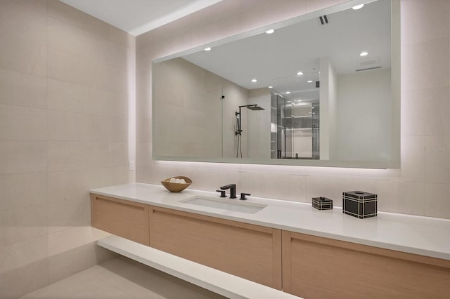 bathroom featuring tile walls, walk in shower, and vanity